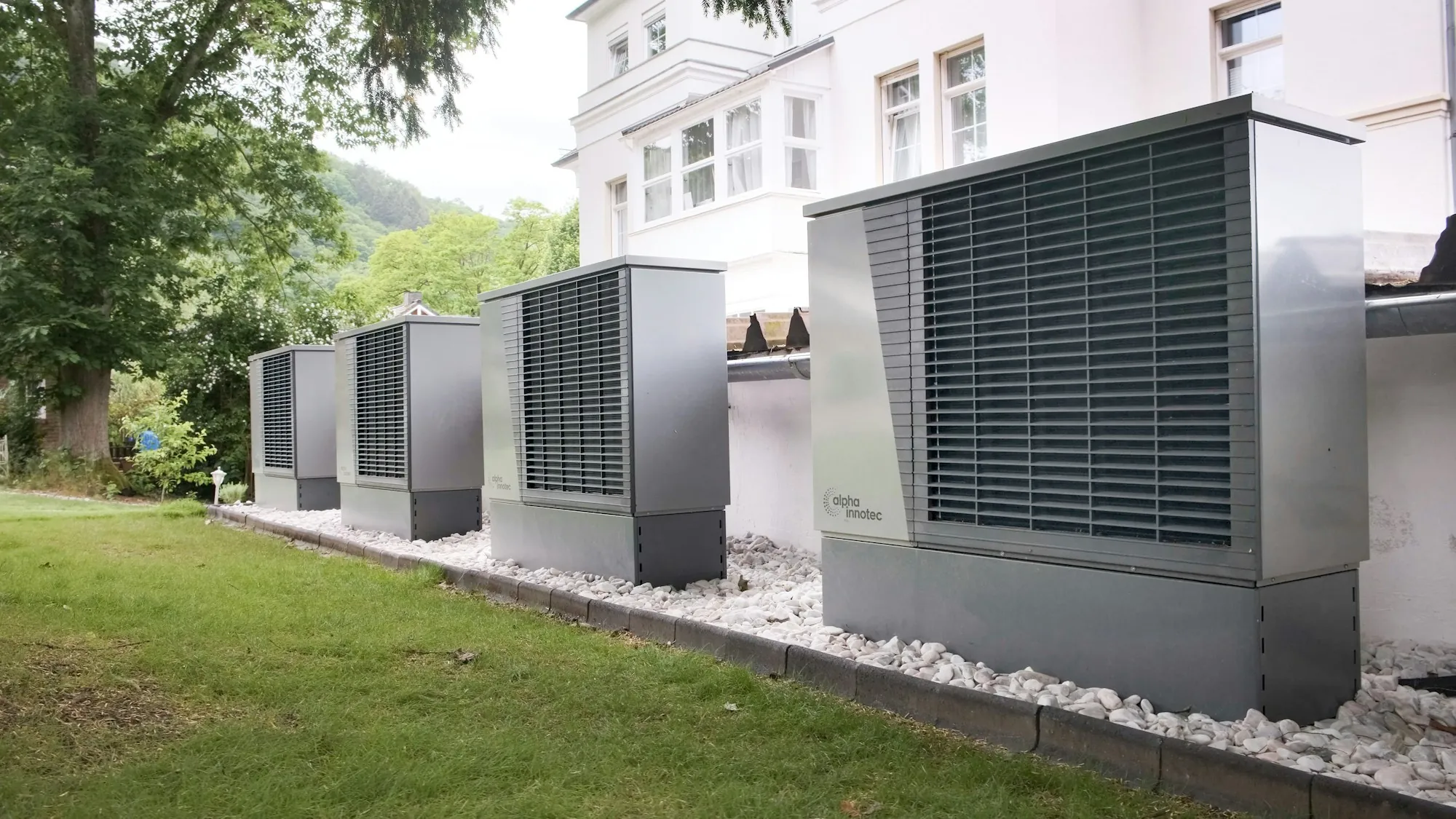 Row of heat pump units on a grassy lawn