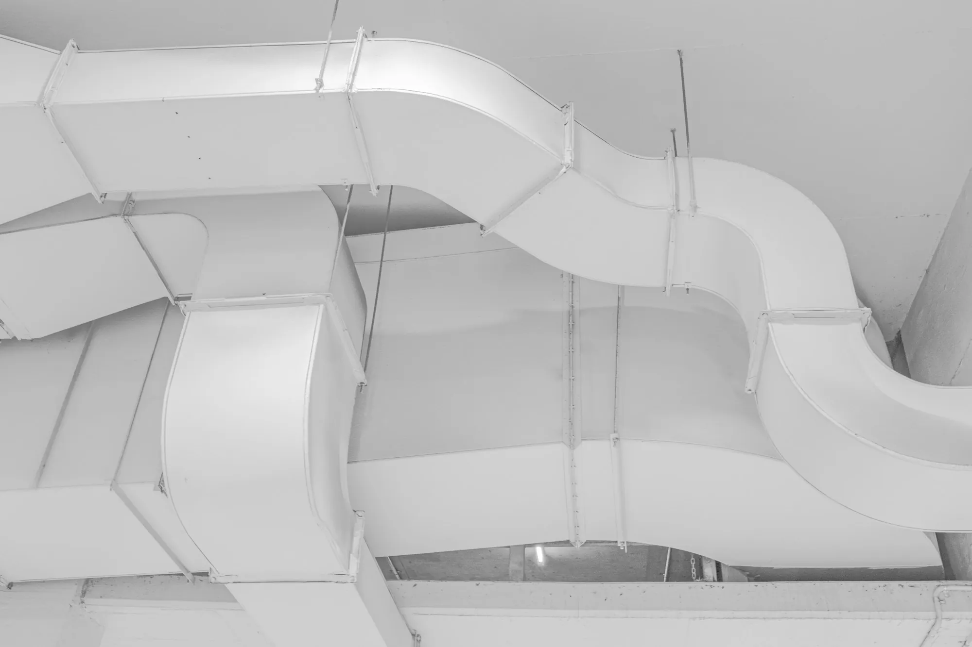 White rectangular ductwork mounted on a ceiling